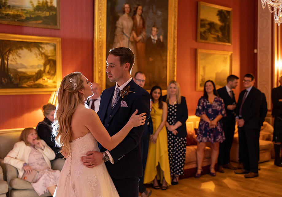 Bride and groom's first dance in room with historic paintings